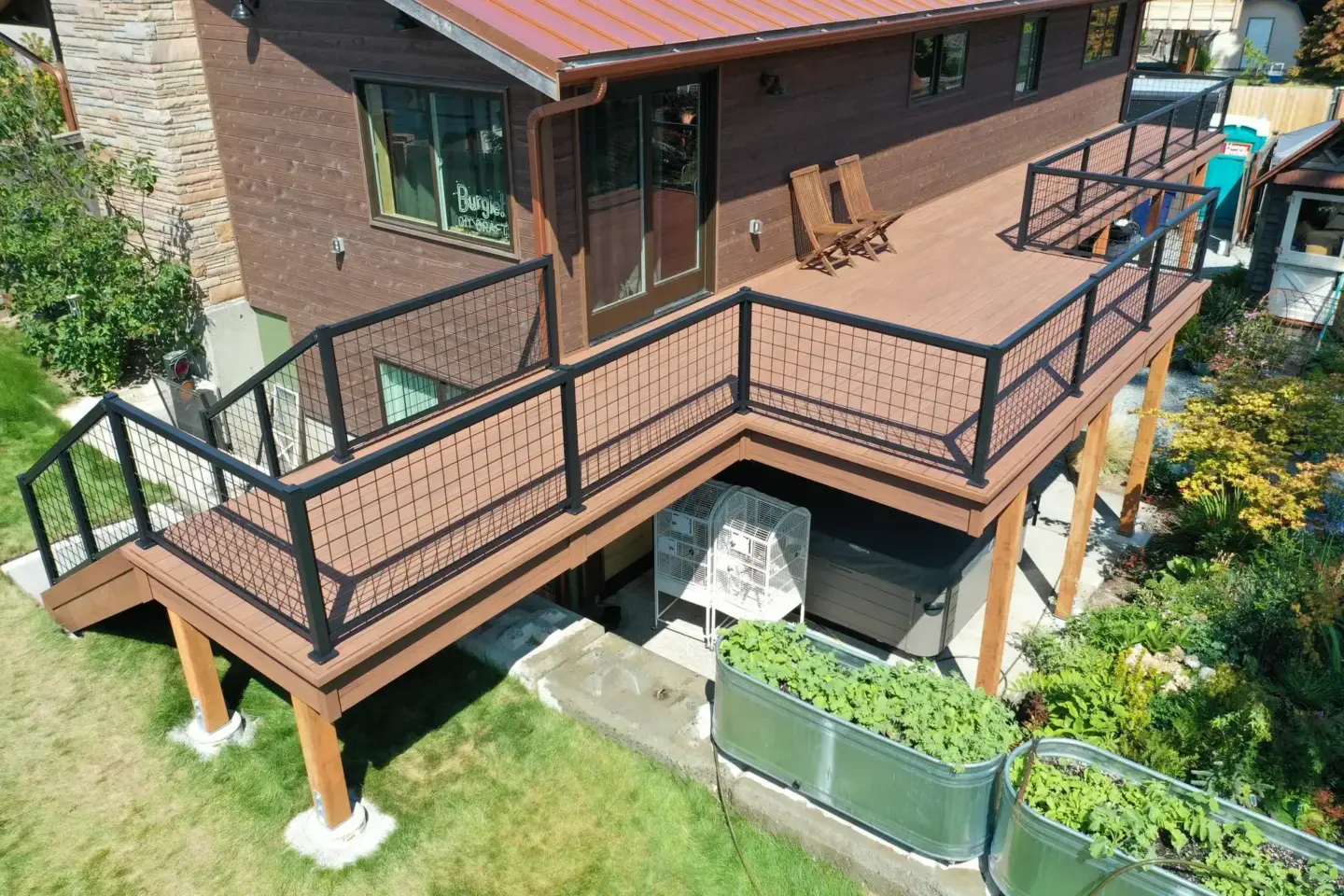 aerial-view-of-the-residential-decking-with-chain-link-railing-with-outdoor-wooden-chair-featuring-greenery-below-the-deck-in-tacoma-wa