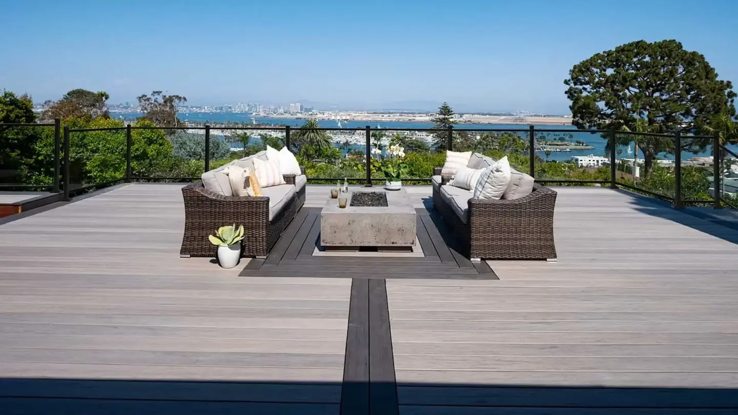 composite-deck-with-glass-railings-and-outdoor-living-sofa-and-fire-pit-featuring-trees-city-and-ocean-view-in-tacoma-wa