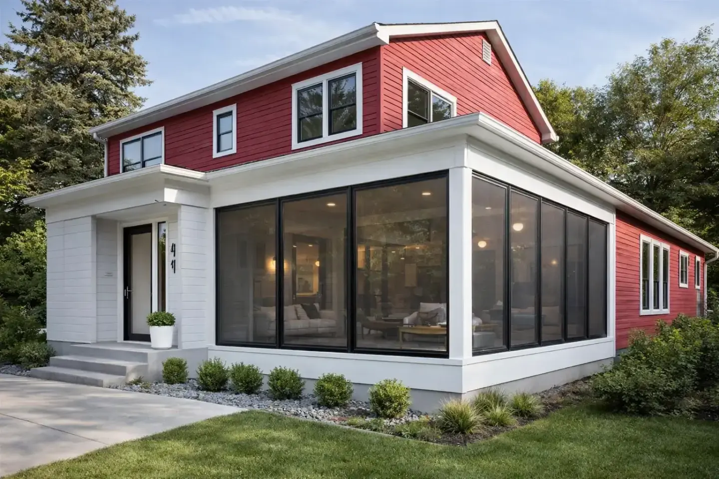 red-house-with-a-porch-enclosure-and-sofa-with-decorative-grass-and-trees-on-the-background-in-tacoma-wa